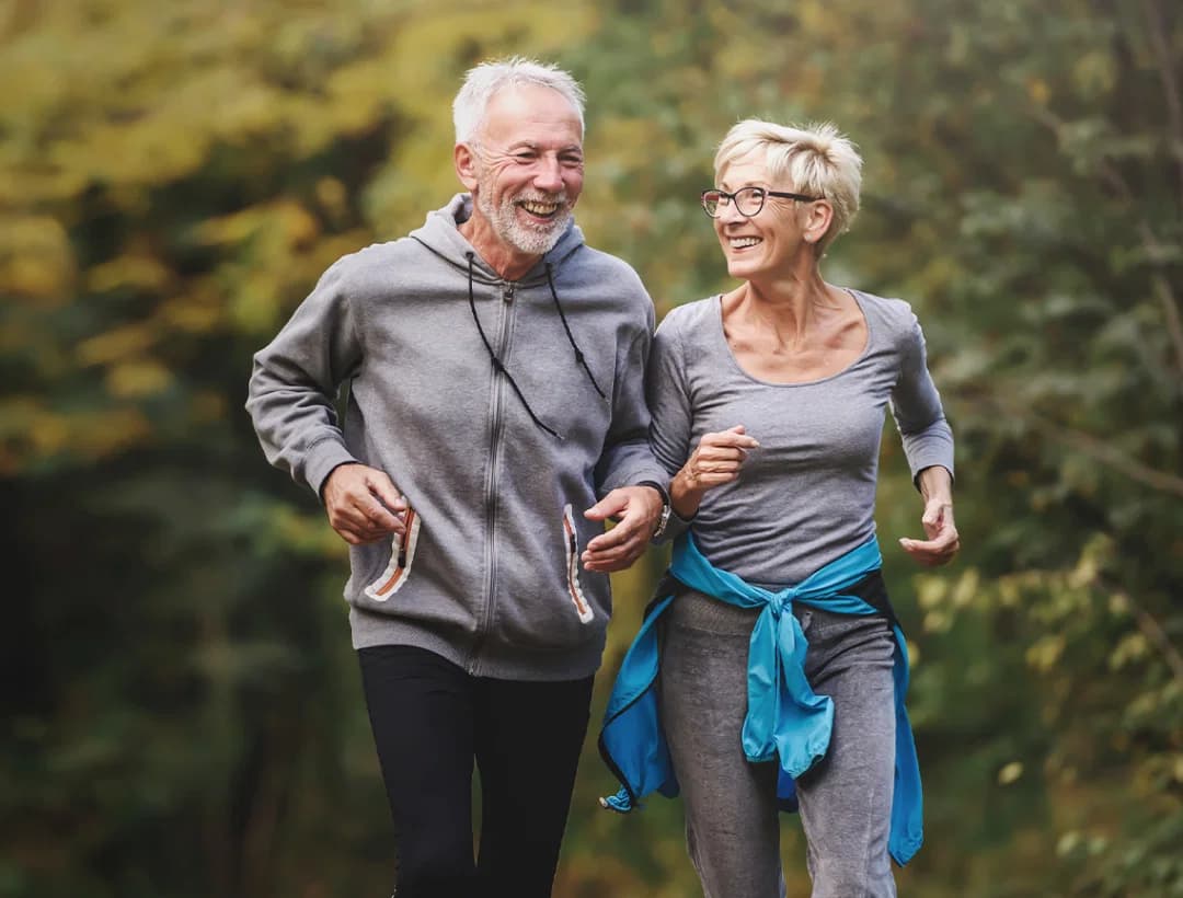 An old couple jogging and smiling