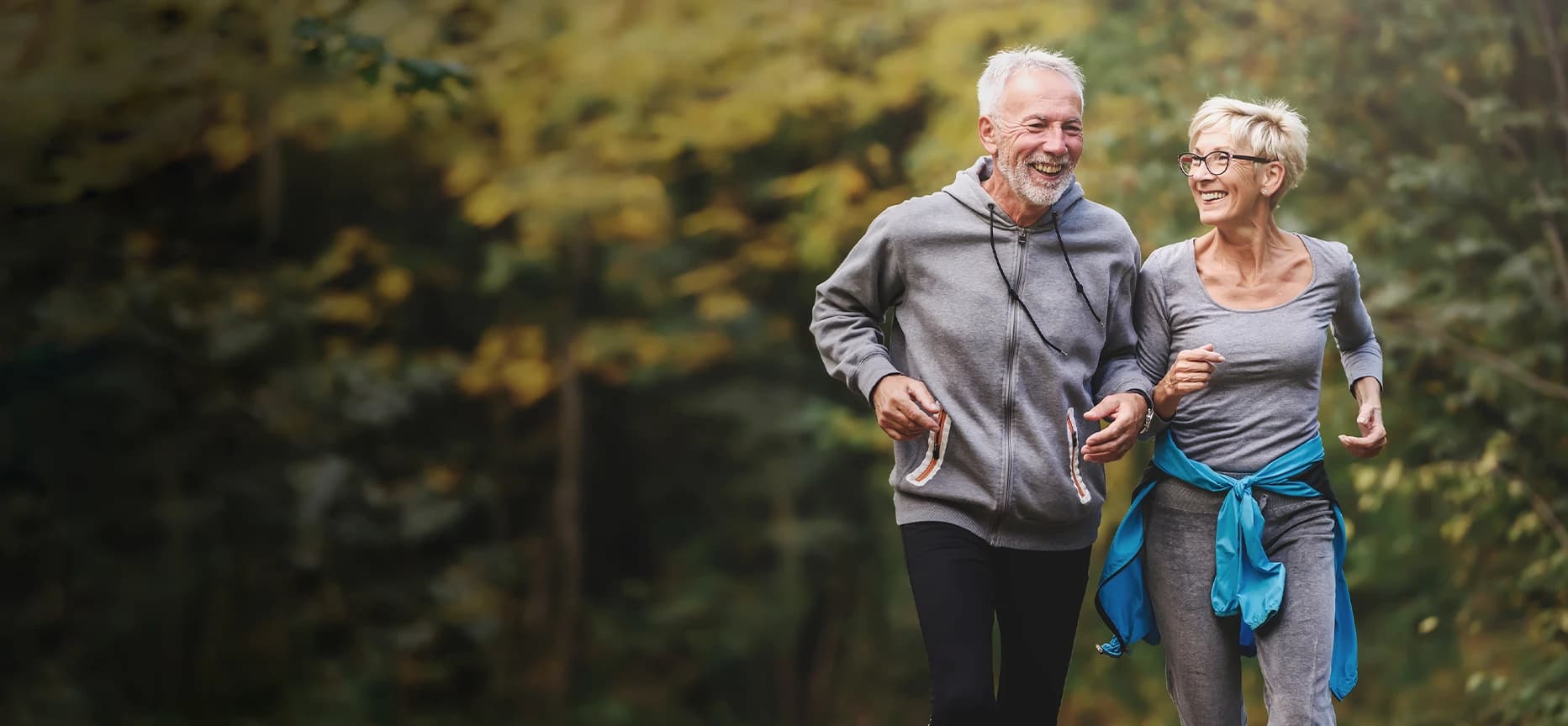 An old couple jogging and smiling